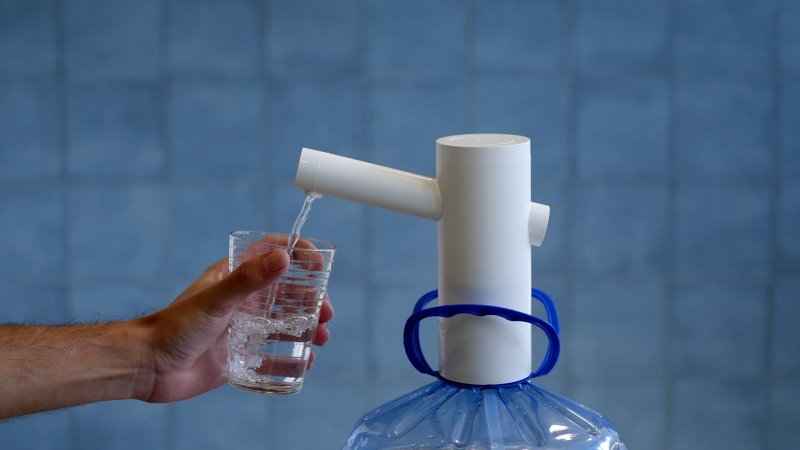 Bomba Elétrica Momo M4 para galão de água - Imagem sobre Segurando copo